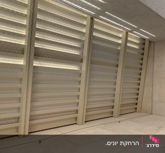 רשת מתוחה על קיר למניעת כניסת יונים